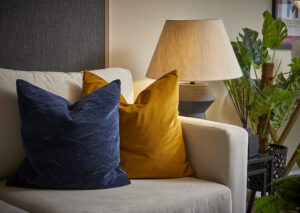 A sofa with cushions and a light